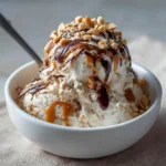 Cottage Cheese Snickers Ice Cream in a bowl topped with chocolate and peanuts