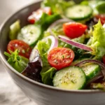Colorful garden salad with mixed greens, tomatoes, cucumbers, and dressing